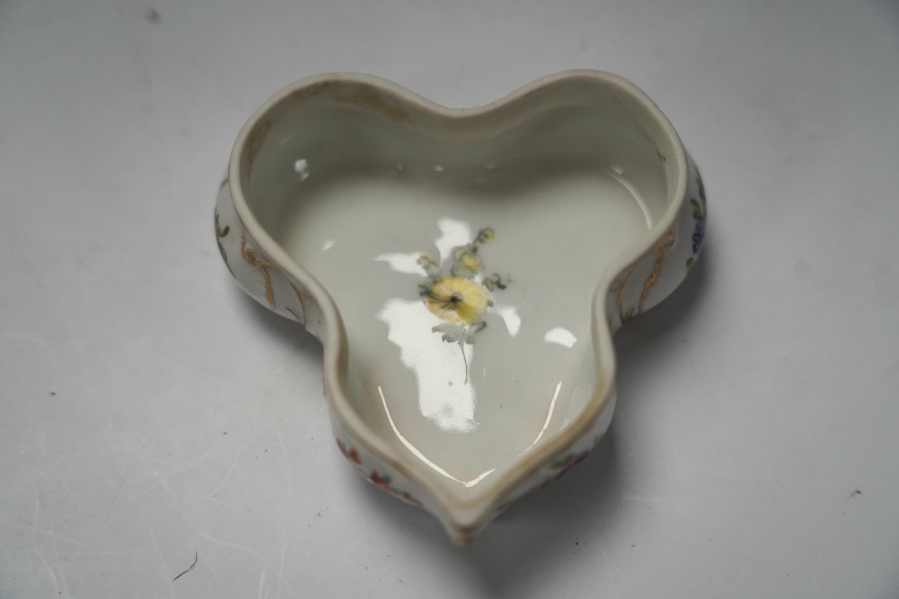 A porcelain shell-shaped centrepiece, a Dresden pill box, a pair of taper holders and a porcelain figure, tallest 21cm